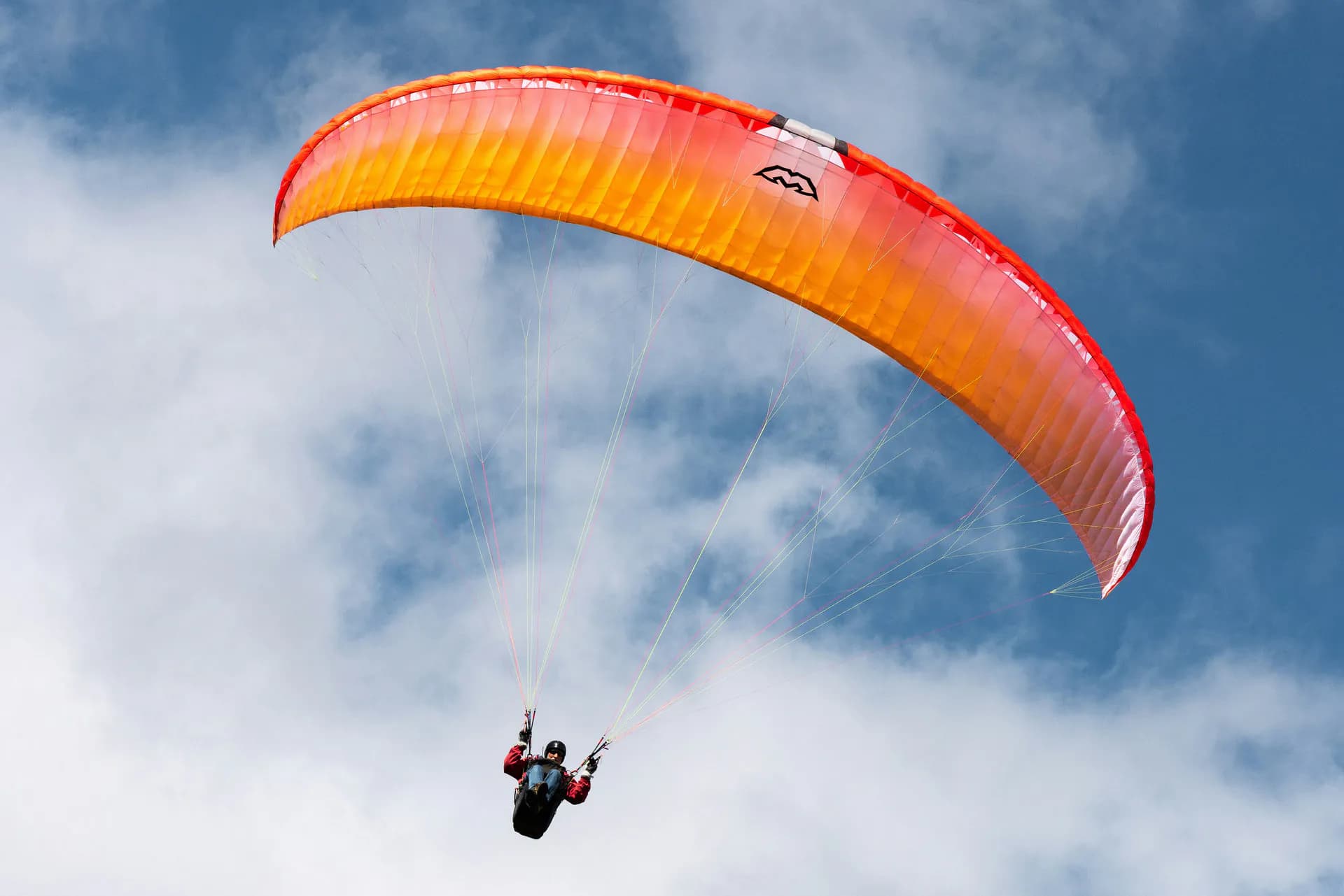 Paraglider soaring through the blue sky over the Shimla and Waknaghat hills